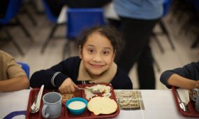 A young female student eats her lunch at Christel House's school in Mexico.