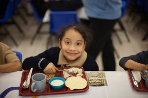 A young female student eats her lunch at Christel House's school in Mexico.