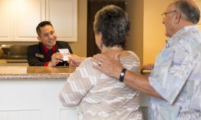 A front desk agent checks in an elderly couple at Coronado Beach Resort