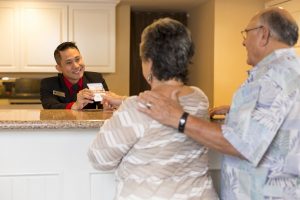 A front desk agent checks in an elderly couple at Coronado Beach Resort