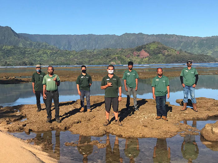 Hanalei Bay Resort Grounds team at beach low tide with mask