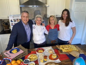 Group smiling with array of red white and blue themed food